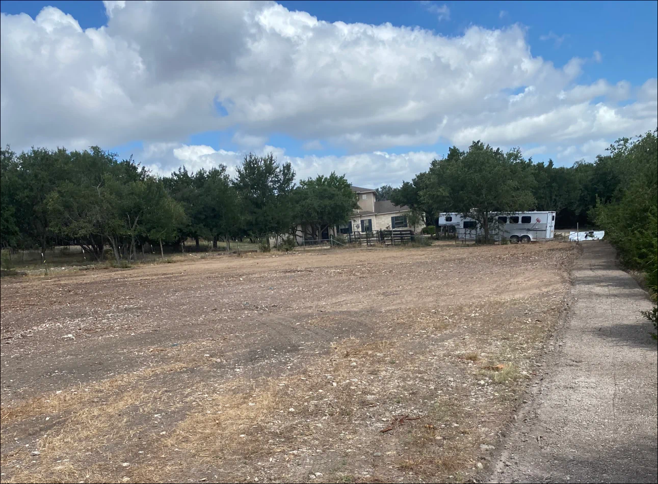 horse arena with small stones and trees around